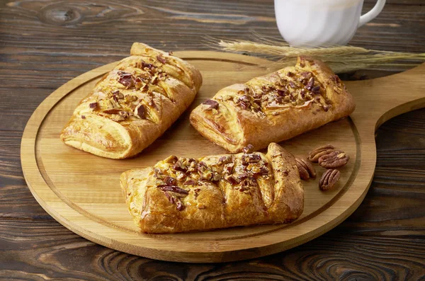 Danish pastry maple pecans with nuts and maple syrup on wooden table — Stockfoto