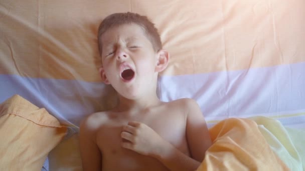 Vista superior de un niño bostezando en la cama — Vídeos de Stock