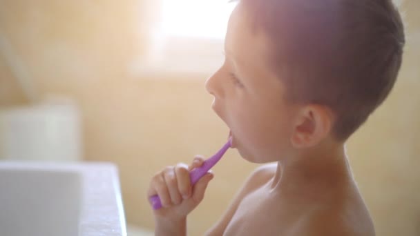 Маленький мальчик чистит зубы в ванной — стоковое видео