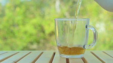 Çay yeşil doğa arka plan üzerinde çaydanlık içine dökülen