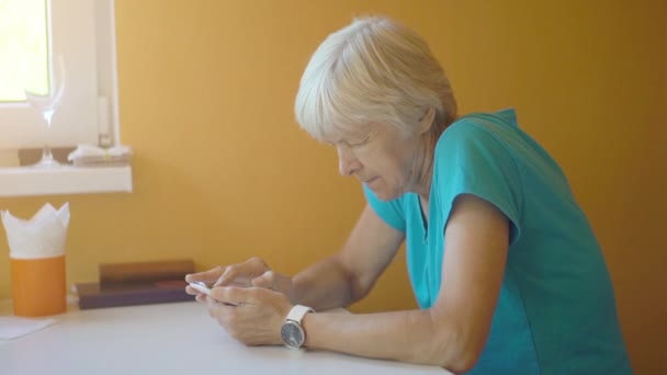 Seniorin nutzt Handy im Wohnzimmer — Stockvideo