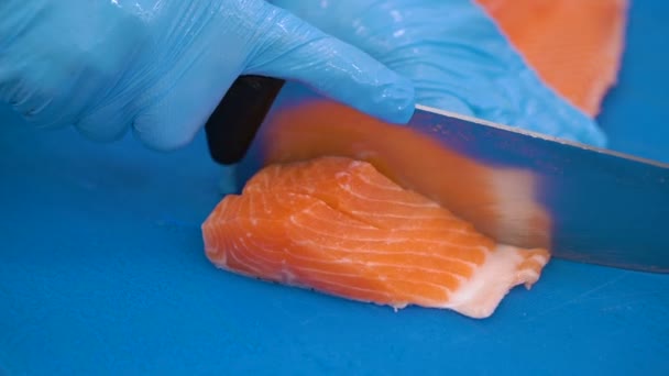 Hand med kniv skär laxfisk. Rå fisk på matlagningsbordet. Kock förbereder rå fisk — Stockvideo