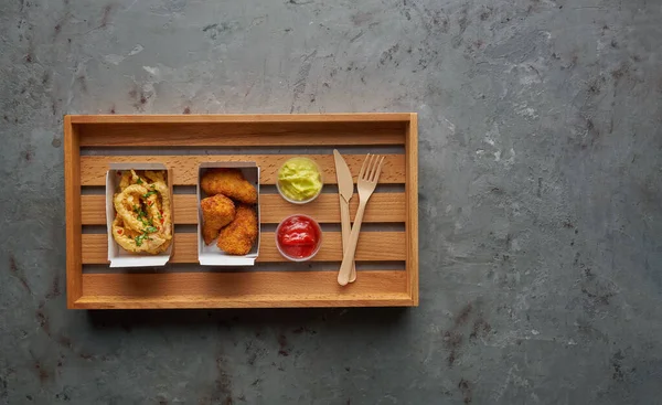 Patas de pollo frito con pulpo crujiente y limonada en bandeja de madera. Concepto de comida callejera, composición horizontal sobre fondo de piedra —  Fotos de Stock