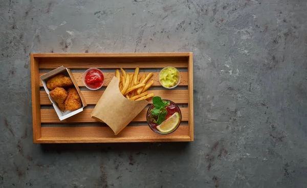 Patas de pollo crujientes fritas con papas fritas y limonada en bandeja de madera. Concepto de comida callejera, composición horizontal con espacio para copias —  Fotos de Stock