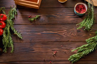 Çeri domatesleri, biberiye ve baharatlar ahşap bir kırsal arka planda.