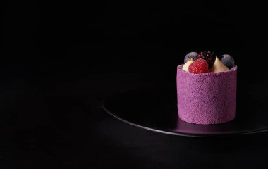 Mor berry mousse kek ile böğürtlen, yaban mersini ve ahududu siyah plaka üzerinde