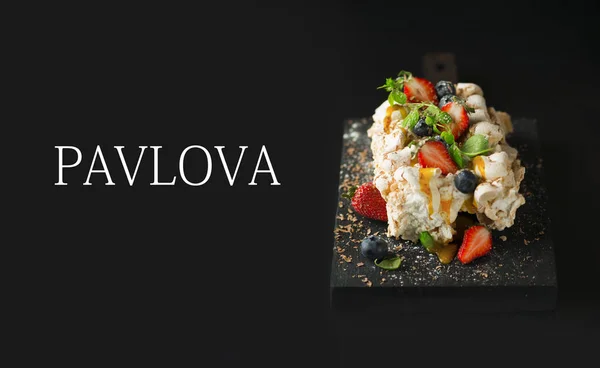 Pavlova cake with fresh strawberries on black background