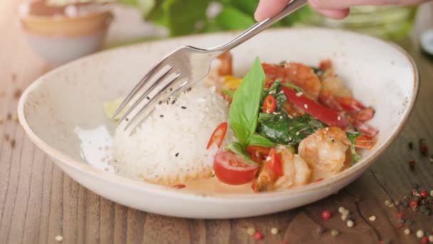 Hombre comiendo delicioso arroz oriental con gambas y verduras — Vídeo de stock