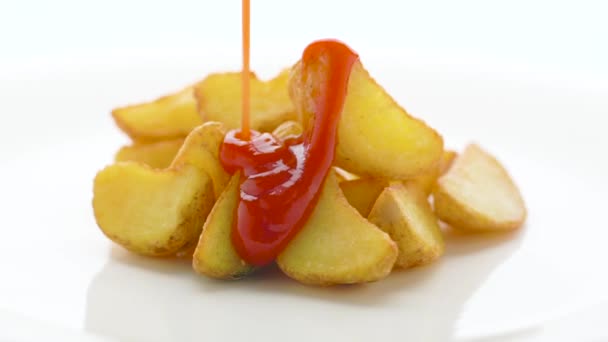 Cuñas de patata frita con salsa de tomate sobre fondo blanco — Vídeo de stock