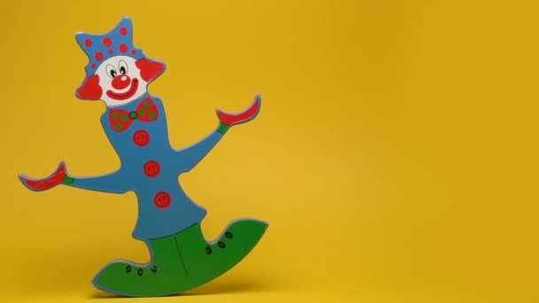 Grappige houten clown op gele achtergrond — Stockvideo