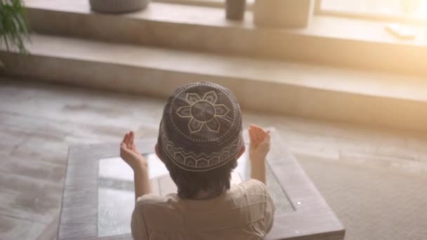 Niño musulmán leer el Corán en el sombrero de oración y ropa árabe con cuentas de rosario y libro del Corán rezando a Allah, profeta Muhammad espíritu santo religión símbolo concepto interior oriental interior — Vídeo de stock