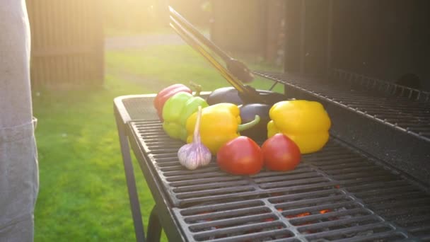 Hand ung man grillning grönsaker på grill plattan med glödande kol, sommar picknick tid, bbq grill med eld i trädgården, — Stockvideo