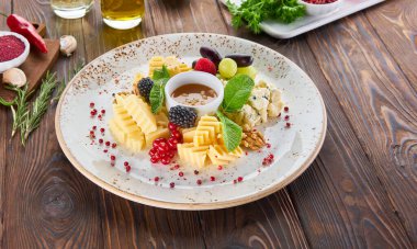 Sos, nane, fındık ve taze böğürtlen ile servis edilen peynir tabağı.