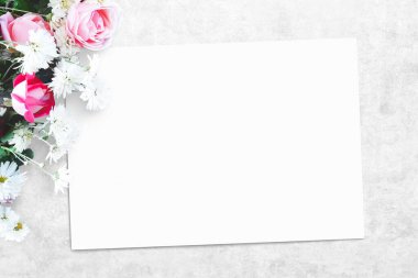 Beton bir masanın üzerinde bir buket çiçek. Kırmızı ve pembe güller, beyaz papatyalar, boş kağıt notlar, tebrik kartları. Doğum günü için çiçek maketi, Sevgililer Günü, Kadınlar Günü. Üst görünüm, düz görünüm, kopyalama alanı