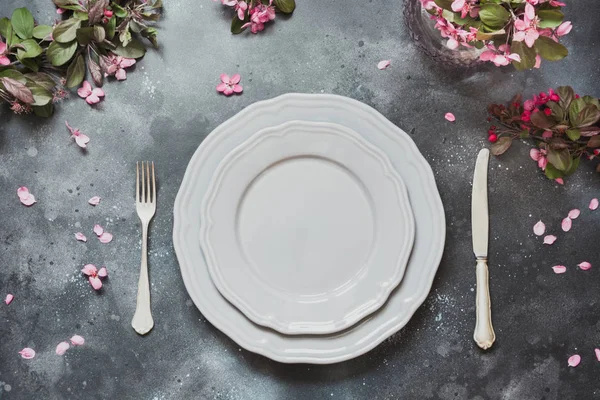 Весняний стіл з романтичними рожевими квітами, посуд на вінтажному фоні. Вид зверху . — стокове фото