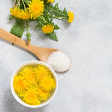 Dandelions üzerinden reçel için malzemeler. Karahindiba, şeker ve su bir ışık yaz zemin üzerine taze çiçekler. Yop görünümü. Kopya alanı.