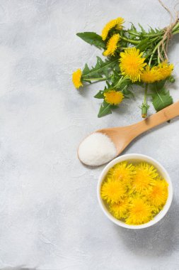 Dandelions üzerinden reçel için malzemeler. Karahindiba, şeker ve su bir ışık yaz zemin üzerine taze çiçekler. Yop görünümü. Kopya alanı.