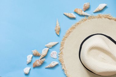 Hasır plaj güneş-şapka ve kabukları punchy mavi. Kadın kıyafeti beach için. Yaz konsepti. Kopya alanı.