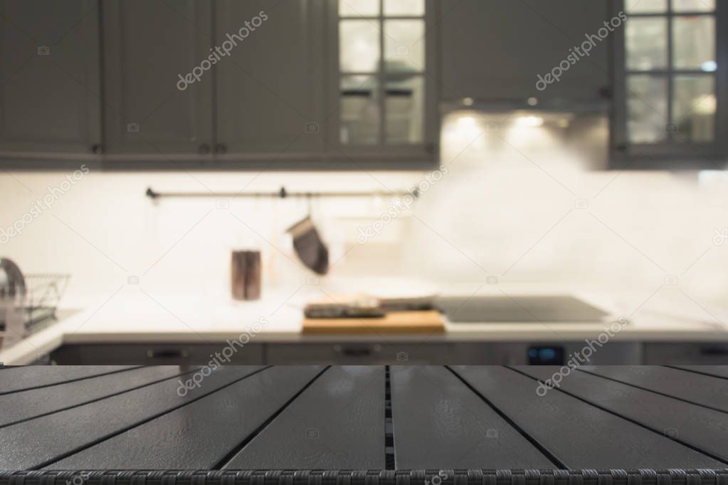 Blurred background. Modern defocused grey kitchen or cafe with wooden tabletop and space for you design.