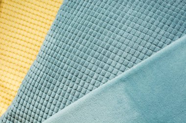 Sarı ve mavi farklı dokular ile çapraz Tekstil, yakın çekim. Üstten görünüm. Soyut Damalı deseni. Kavramı kum ve deniz.
