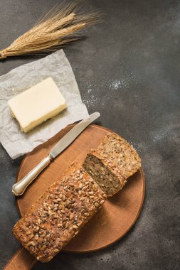 Somun Çavdar ekmek buğday ve tereyağı, kesme tahtası üzerinde dilimlenmiş. Yakın çekim. Senin metin için yer.