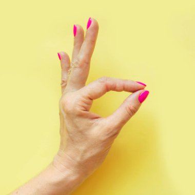 Sarı pembe tırnak ile el. Kavramı.