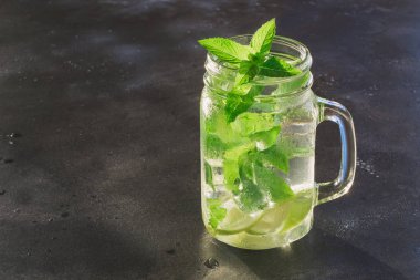 Bir mojito Kokteyl garnitür siyah masada mason kavanoza. Yakın çekim. Metin için yer kopyalayın.