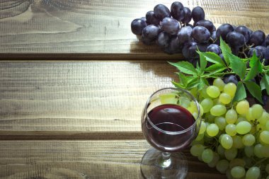 Bardağı kırmızı şarap ve ahşap masa Olgun üzüm. Kadar yakın ve alanı Kopyala.