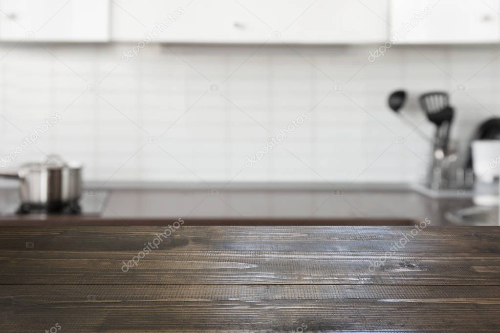 Blurred background. Modern defocused pastel kitchen with empty wooden tabletop and space for you design.