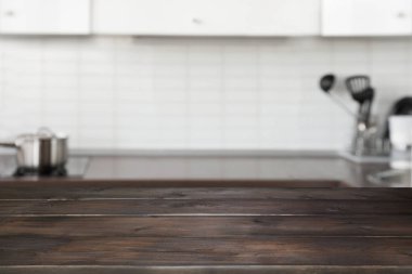 Arka plan bulanık. Boş ahşap masa ve yer için tasarım modern ufuk pastel mutfak.