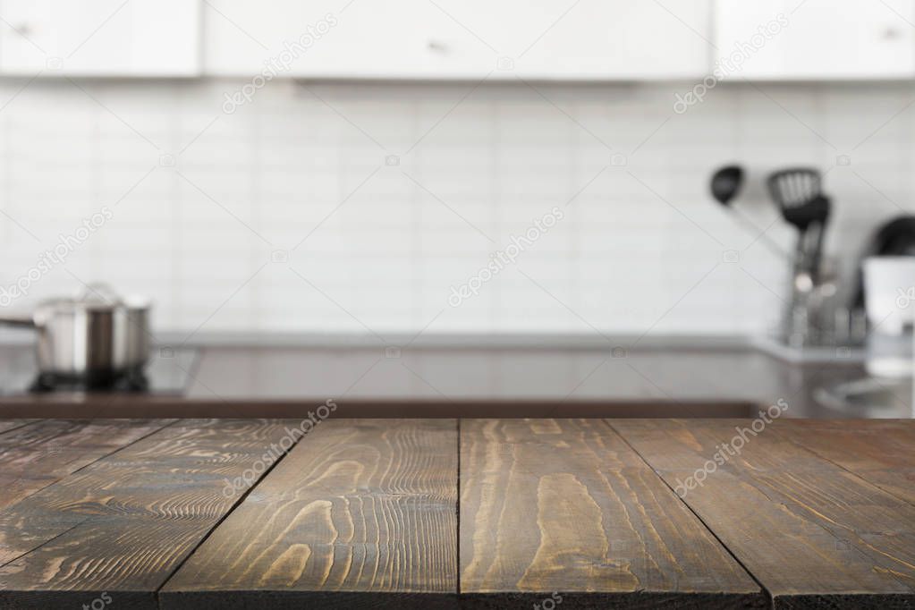 Blurred background. Modern defocused pastel kitchen with empty wooden tabletop and space for design.