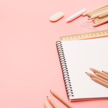 Üzerine pastel pembe renkli okul malzemeleri. Üstten görünüm, düz yatıyordu. Metin için yer.