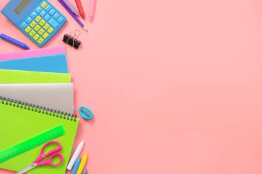 Üzerine pastel pembe renkli okul malzemeleri. Üstten görünüm, düz yatıyordu. Metin için yer.