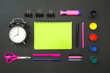 Renkli okul malzemeleri, pembe kitap ve siyah kara tahta çalar saat. Üstten görünüm, düz yatıyordu, kopya alanı. Okula dönüş.