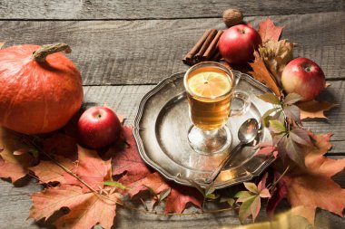 Sonbahar natürmort. Bardak çay ile sonbahar yaprakları ve kabaklar ahşap tahta üzerinde dekor.
