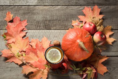 Sonbahar yaprakları ve kabaklar ahşap tahta üzerinde dekor ile fincan da çay. Sonbahar natürmort.