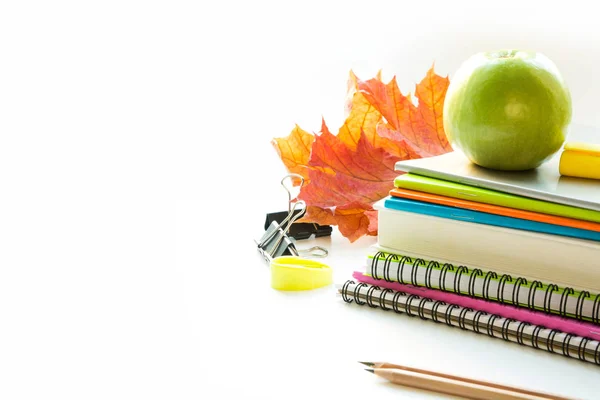 Material escolar colorido, libro, manzana sobre blanco. De cerca. Regreso a la escuela . — Foto de Stock