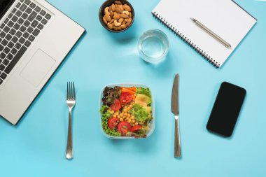 Sağlıklı bir iş öğle yemeği ofis, salata, badem, mavi su. Üstten görünüm kopya alanı ile. Kavram sağlıklı beslenme. Beslenme çantası. Yapılacaklar listesi.