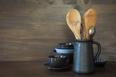 Çanak çömlek, clayware, karanlık kaplar ve ahşap masa üstü diğer farklı şeyler. Mutfak natürmort tasarımı için arka plan olarak yemek pişirmek için. Kopya alanı.