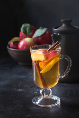 Baharatlı, limonlu çay bardak dilimlenmiş elma ve tarçın siyah kurulu. Sonbahar natürmort.