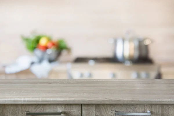 Fundo desfocado. Cozinha moderna com mesa de madeira vazia e espaço para você . — Fotografia de Stock