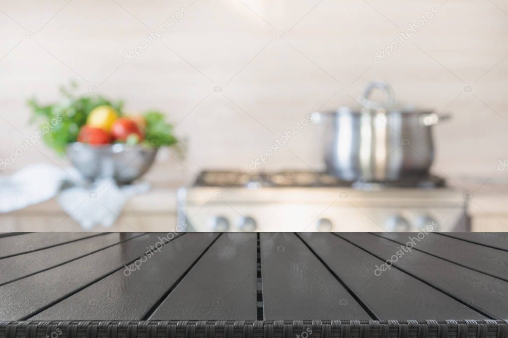 Blurred background. Modern kitchen with empty wooden tabletop and space for you.