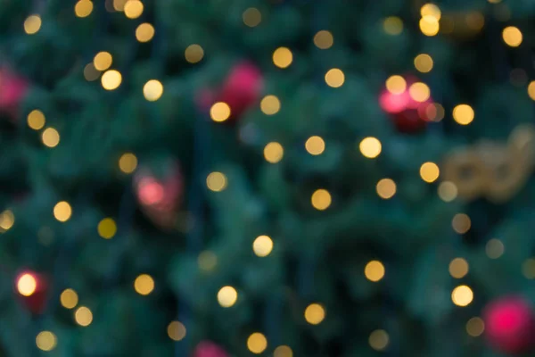 Blurred Christmas tree with golden garland and red balls. Abstract pattern. Defocused background. — Stock Photo, Image