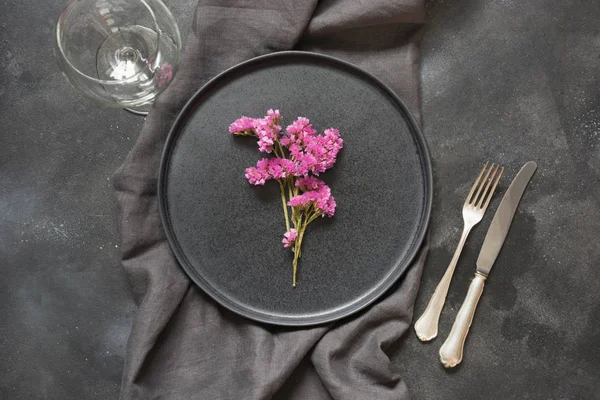 黒いテーブルのピンクの野花と優雅さの場所の設定。トップ ビュー. — ストック写真