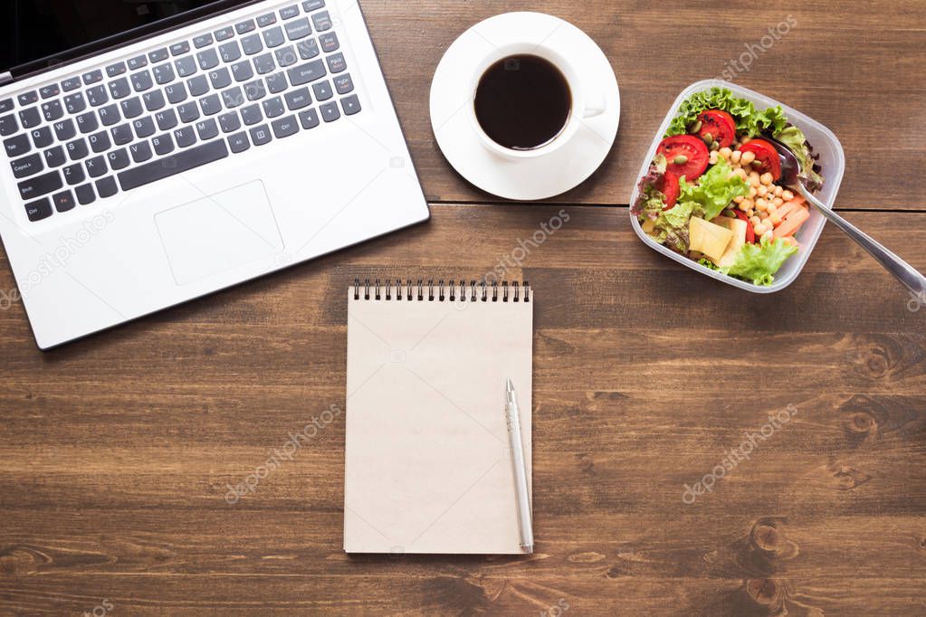 Workplace, healthy business lunch, salad, coffee on wooden table. Top view, copy space. Planning weight loss. To do list. Lunchbox