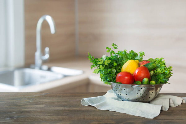Blurred background. Modern kitchen with fresh vegetables on wooden tabletop, space for you and display products.
