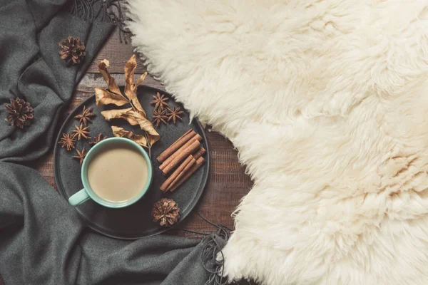 Hygge natürmort sıcak fincan sade kahve, anason, furskin ve ahşap tahta üzerinde sıcak eşarp ile. Uzay kopyalayın. Yukarıdan görüntülemek.