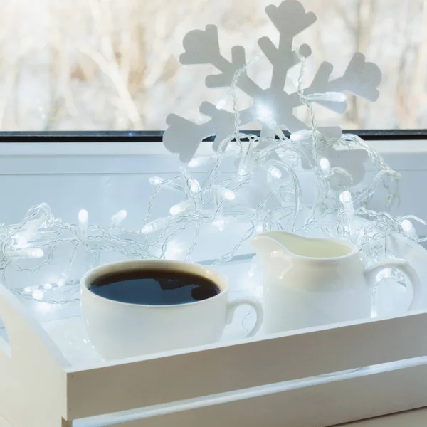 Tasse schwarzen Kaffee auf der Winterfensterbank. Weihnachtszeit. — Stockfoto