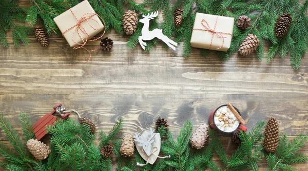 Christmas holiday banner - tree, gifts, deer, cone and decoration on wooden board. Holiday banner. Top view.