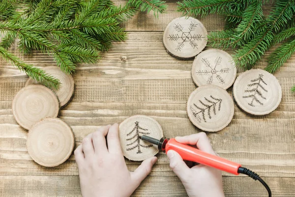 Kerst zelfgemaakte Pyrogravure speelgoed. Houten segment. Xmas decoratie. Kind maakt giften voor familieleden. Bekijk van bovenaf. Alternatieve decor. — Stockfoto